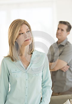Angry Woman Looking Away With Man In Background At Home