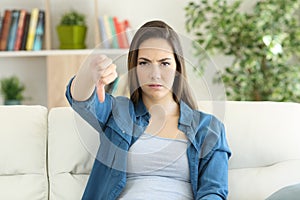 Angry woman looking at camera with thumbs down