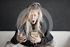 Angry woman looking at phone