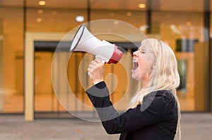 Angry woman protester yelling into a megaphone