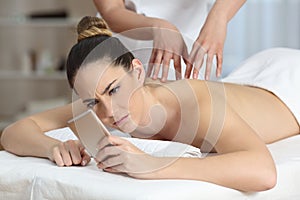 Angry woman receiving a message during massage