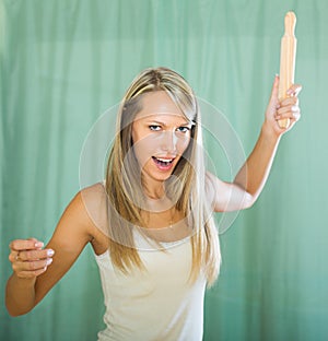 Angry woman with rolling-pin in hand