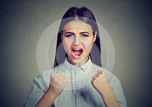 Angry woman screaming with fists up in air