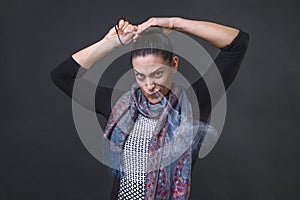 Angry woman screaming in frustration, furious unable to tie her pony tail and steaming out of her nose