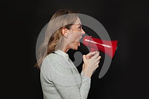Angry woman screaming with loudspeaker megaphone on blackboard background