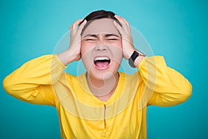 Angry woman screaming out and pulling her hair over background