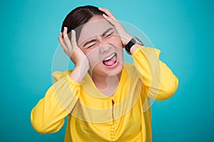 Angry woman screaming out and pulling her hair over background