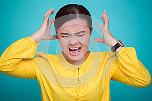 Angry woman screaming out and pulling her hair over background