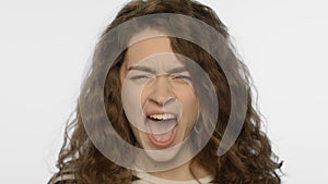 Angry woman screaming in studio. Portrait of rage girl scream on white photo