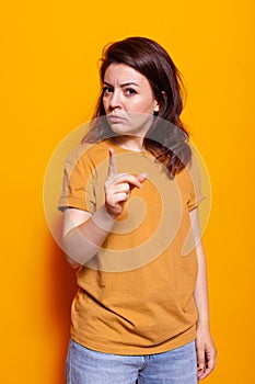 Angry woman with serious face pointing finger at camera