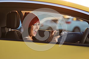 Angry woman shouting on cell phone driving a car