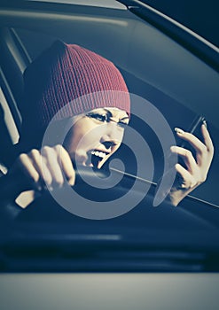 Angry woman shouting on cell phone in her car