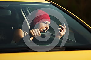 Angry woman shouting on the phone in a car