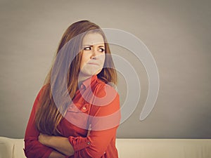 Angry woman sitting on sofa