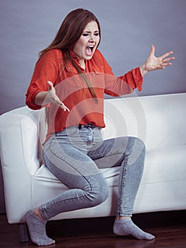 Angry woman sitting on sofa