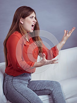 Angry woman sitting on sofa