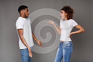 Angry woman standing and blaming at unhappy man