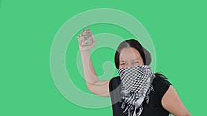 Angry woman with stone in hands on national strike on green background. Furious woman in bandana showing fist and rock