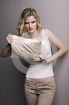 Angry woman straching a pillow