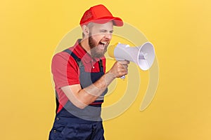 Angry worker man holding megaphone near mouth loudly speaking, screaming, protesting.