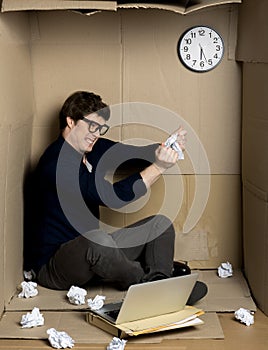 Angry worker is tearing paper inside small cardboard box