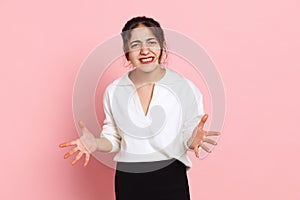 Angry young arabian girl in white blouse posing isolated on pink background. Concept of emotions, problems, inner world