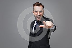 Angry young bearded business man in suit shirt tie posing isolated on grey background. Achievement career wealth