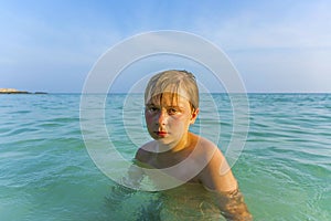 Angry young boy in the beautiful ocean