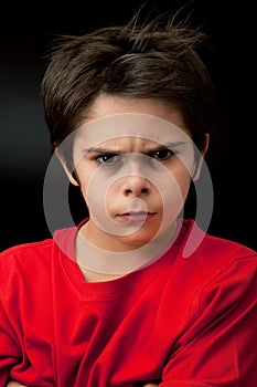 Angry young boy in dark background