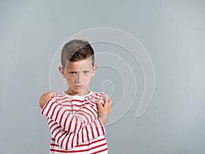 Angry young boy isolated on gray background