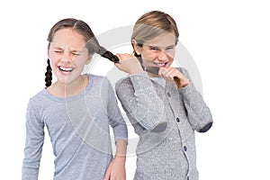 Angry young boy pulling sister hair in a fight