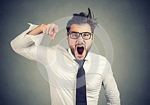 Angry young business man accusing someone screaming photo