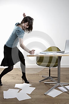 Angry Young Businesswoman Banging At Desk photo