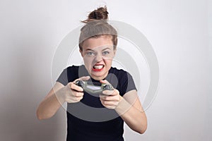 Angry young Caucasian woman girl holding joystick game pad controller, playing computer game.