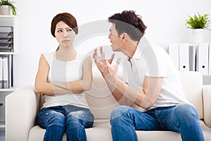 Angry young couple sitting on the sofa