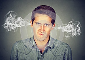 Angry young man, blowing steam coming out of ears