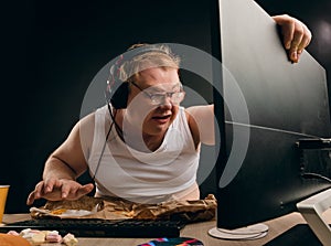 Angry young man in headset playing game at home