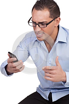 Angry young man looking at his mobile phone