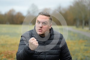 Angry young man menacing the camera with his fist