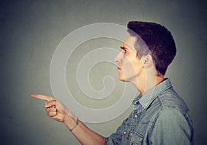 Angry young man pointing finger at someone