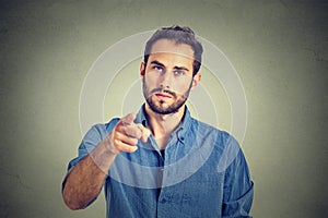 Angry young man pointing finger at you camera gesture