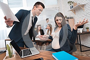 Angry young man in suit screams at pregnant girl in office. Pregnancy at work.