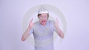 Angry young man with tinfoil hat complaining and pointing at camera