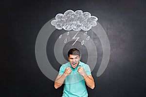 Angry young man yelling over background of chalkboard