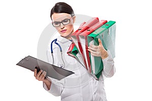 Angry young woman doctor with stethoscope holding binders in her hands in white uniform on white background