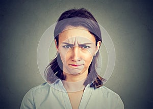 Angry young woman on gray background.