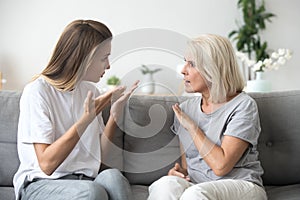 Angry young woman having disagreement with annoyed old mother