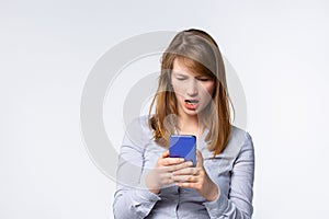 Angry young woman looking at smartphone frustrated by no signal or scam message, mad female disappointed by bad news