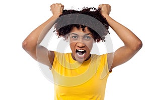 Angry young woman pulling her hair out photo