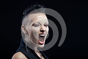 Angry young woman screaming isolated on black background